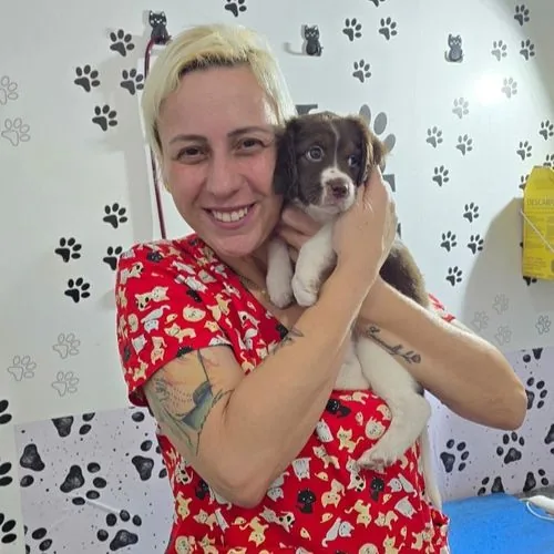 Dra. Cris segurando um filhote de cachorro